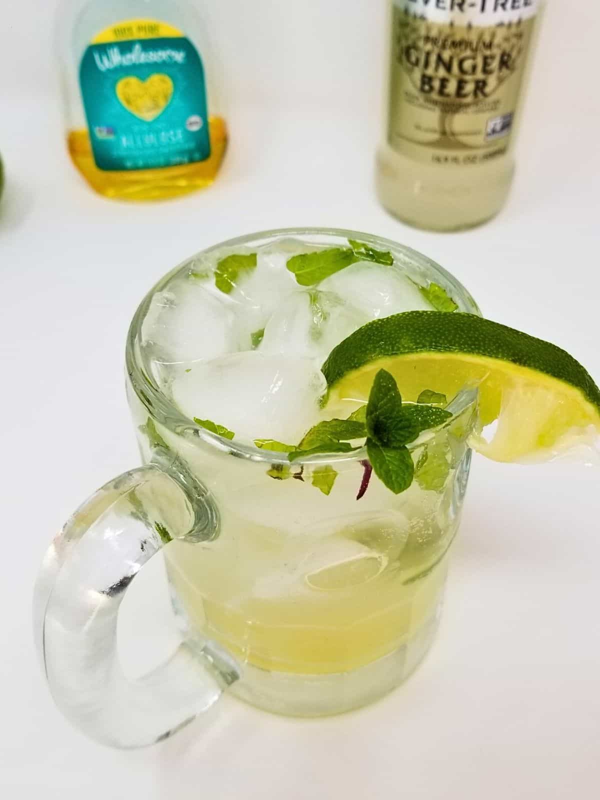 a glass of ice-cold virgin moscow mule mocktail topped with a slice of fresh lime fruit.