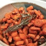 baked garlic and rosemary carrots with maple glaze in a bowl.