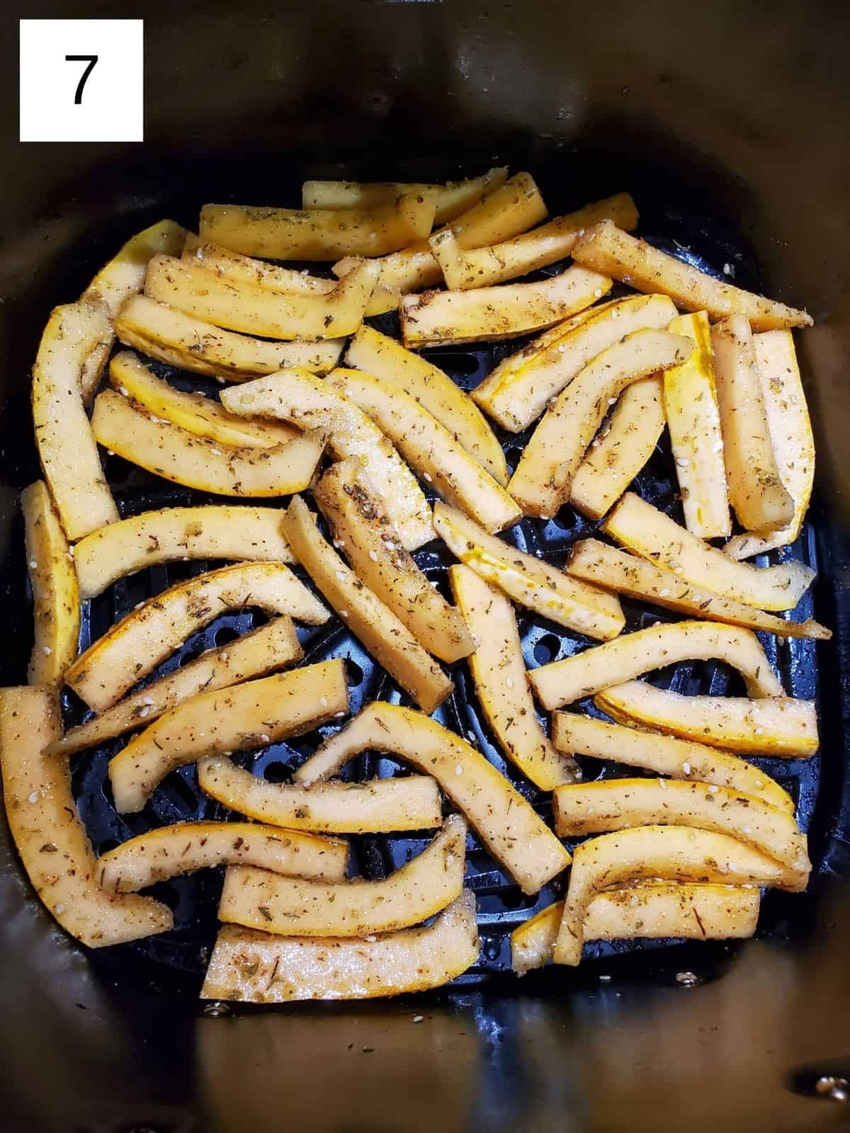 seasoned delicata squash fries in a preheated air fryer.