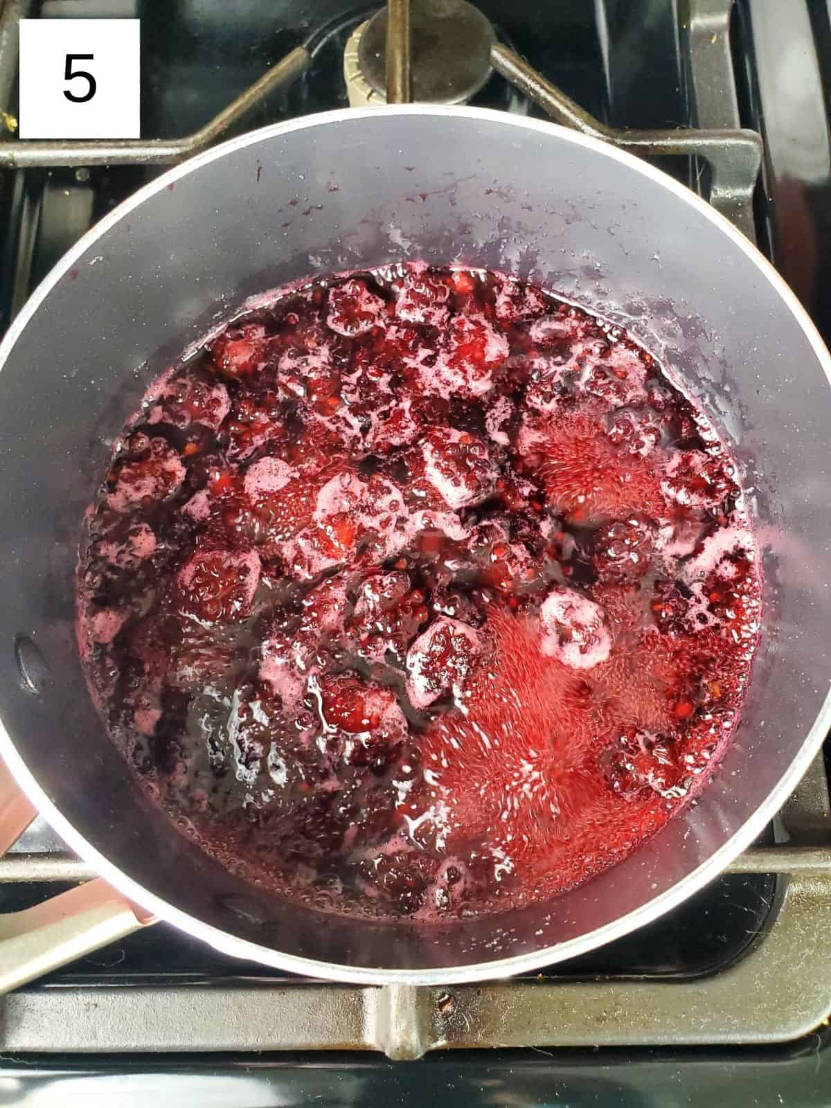 a saucepan of sweetened and pulverized blackberries.