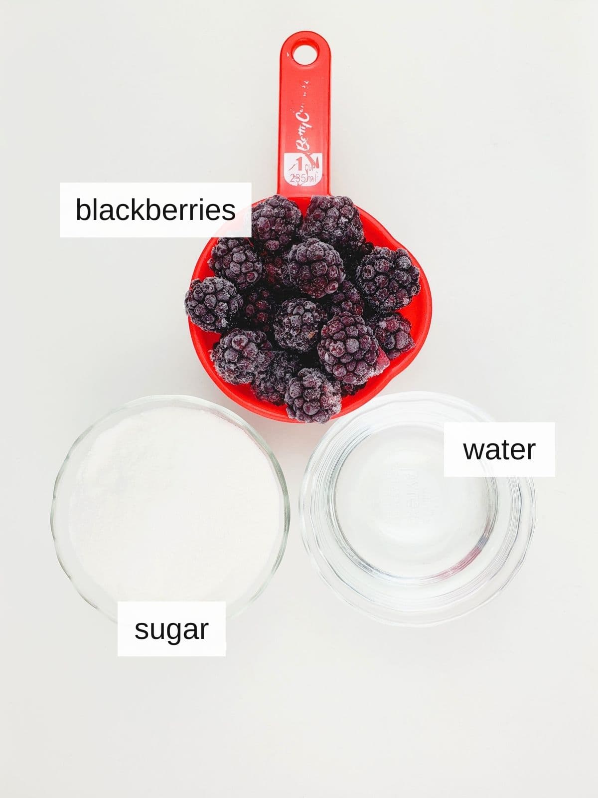 ingredients for blackberry simple syrup, including frozen blackberries, sugar, and water