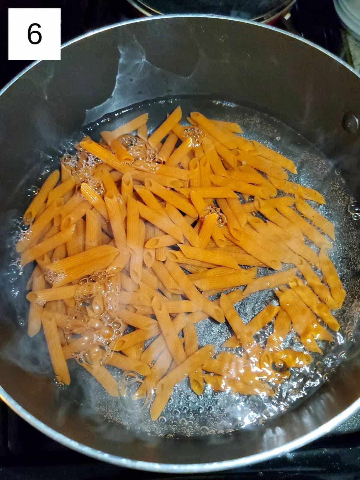 red lentil penne pasta in a pot of boiling water.