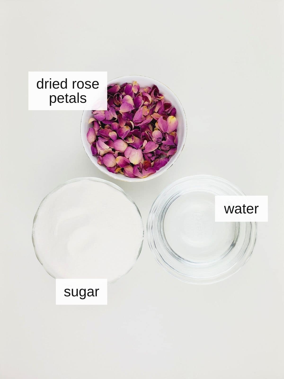 ingredients for rose simple syrup, including dried rose petals, sugar, and water.
