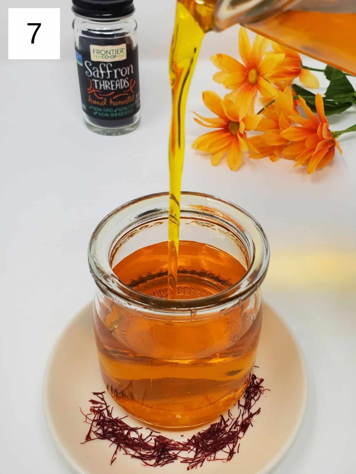saffron syrup being poured into a glass container.