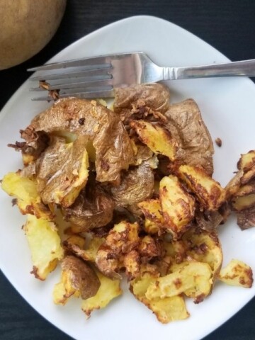 air fried smashed potatoes on a plate.