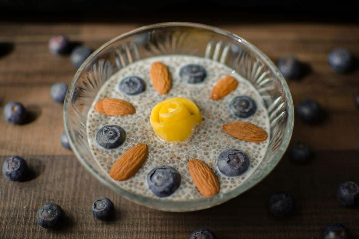 a bowl of chia seed pudding topped with vibrant blueberries and almonds..