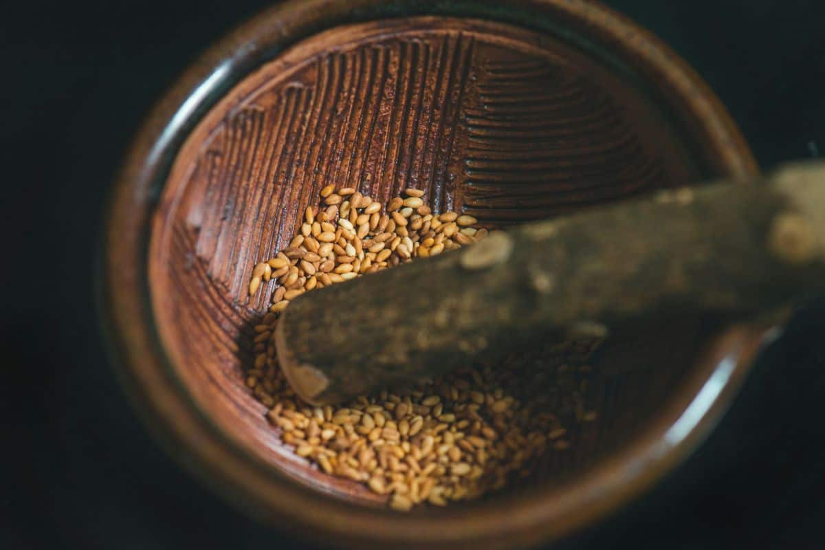 roasted sesame seeds in a wooden grinding bowl..