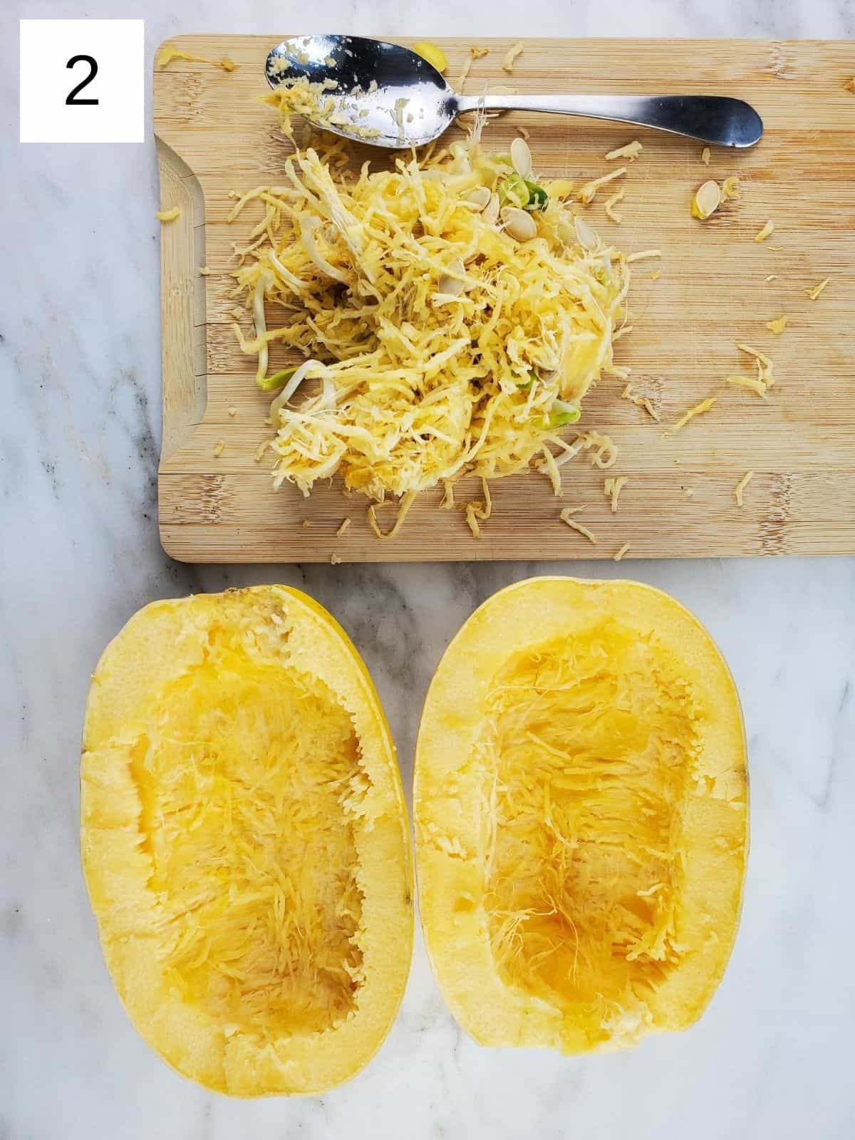 scooped out seeds of spaghetti squash on a wooden cutting board.