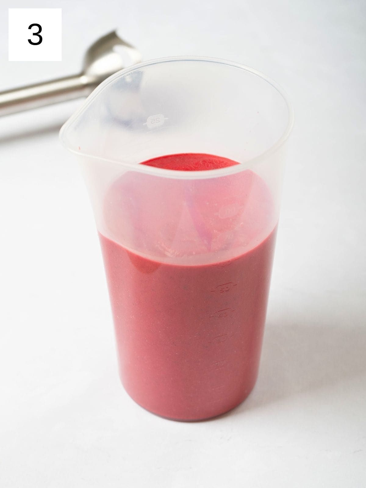 a mixture of beets, spices, and coconut milk in a plastic cup.
