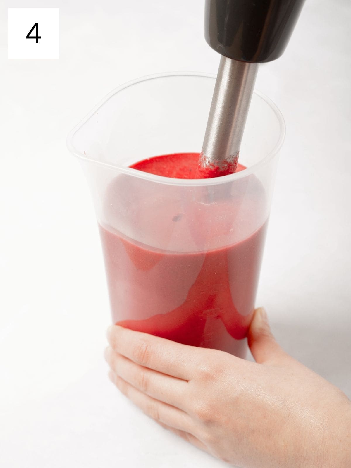 a purée mixture of beets, spices, and coconut milk in a plastic cup.