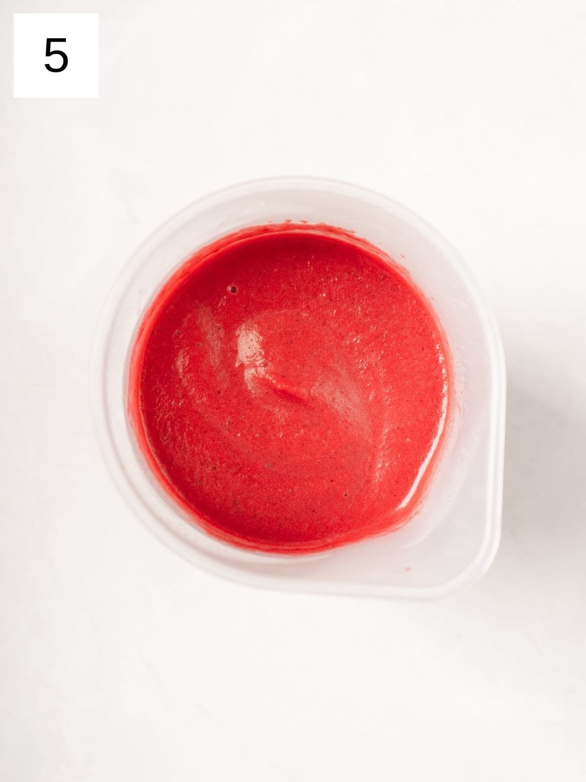 a purée mixture of beets, spices, and coconut milk in a plastic cup.