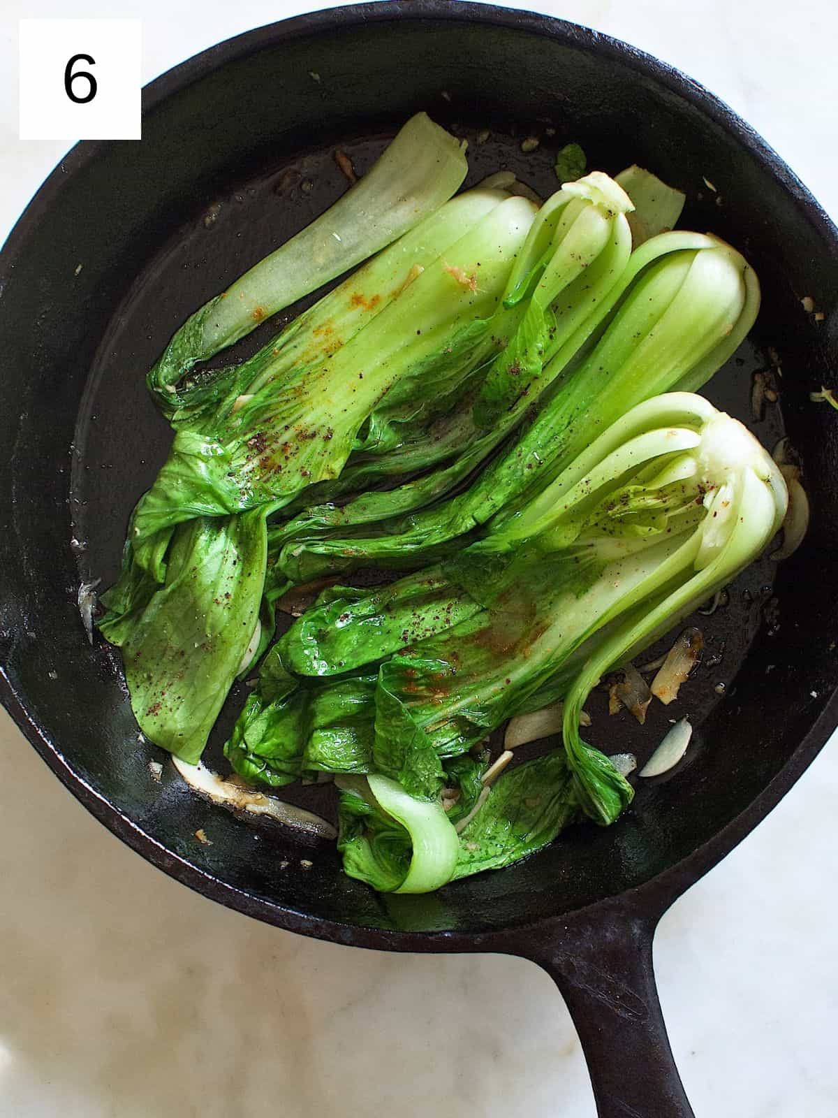 a mixture of spices on top of garlic and ginger-seasoned bok choy.