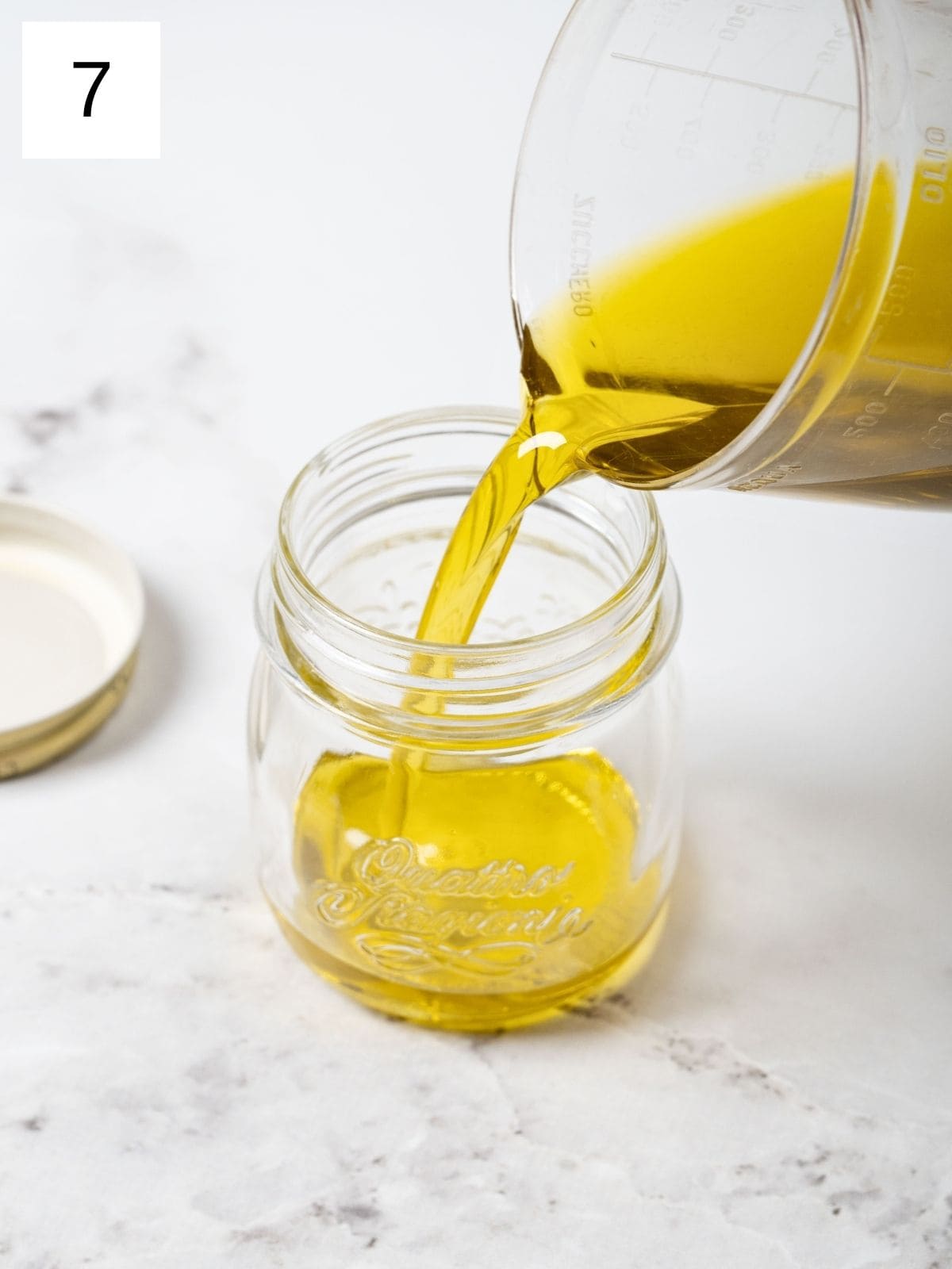 pouring garlic-infused olive oil into a glass container.