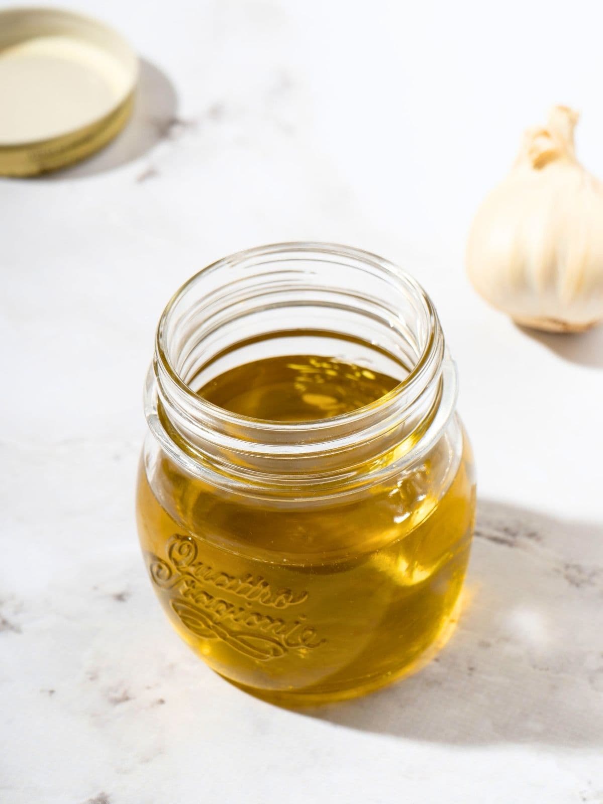 garlic-infused olive oil, made with olive oil and garlic, in a glass container.