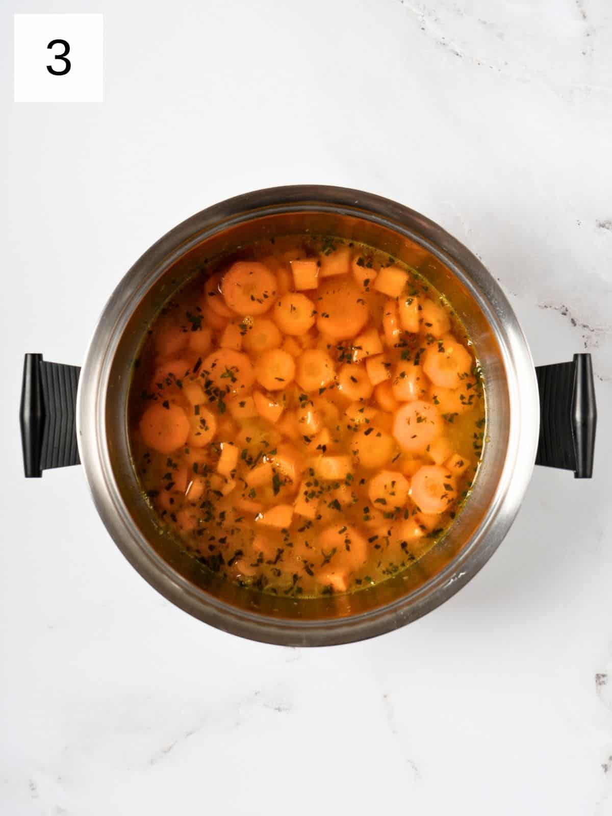 seasoned sweet potatoes and carrots with vegetable broth in a pot.