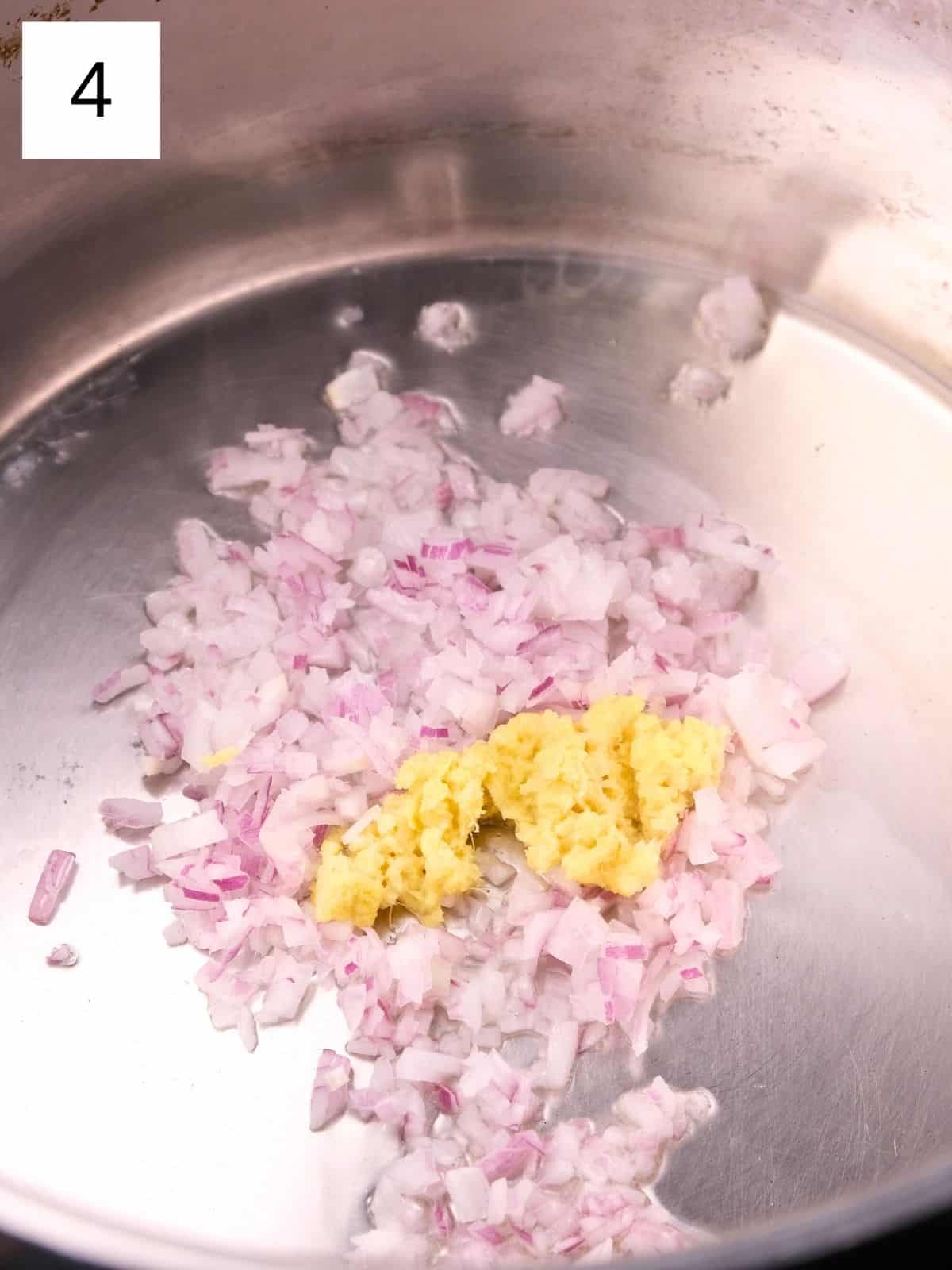 minced red onions and grated ginger in a pot.