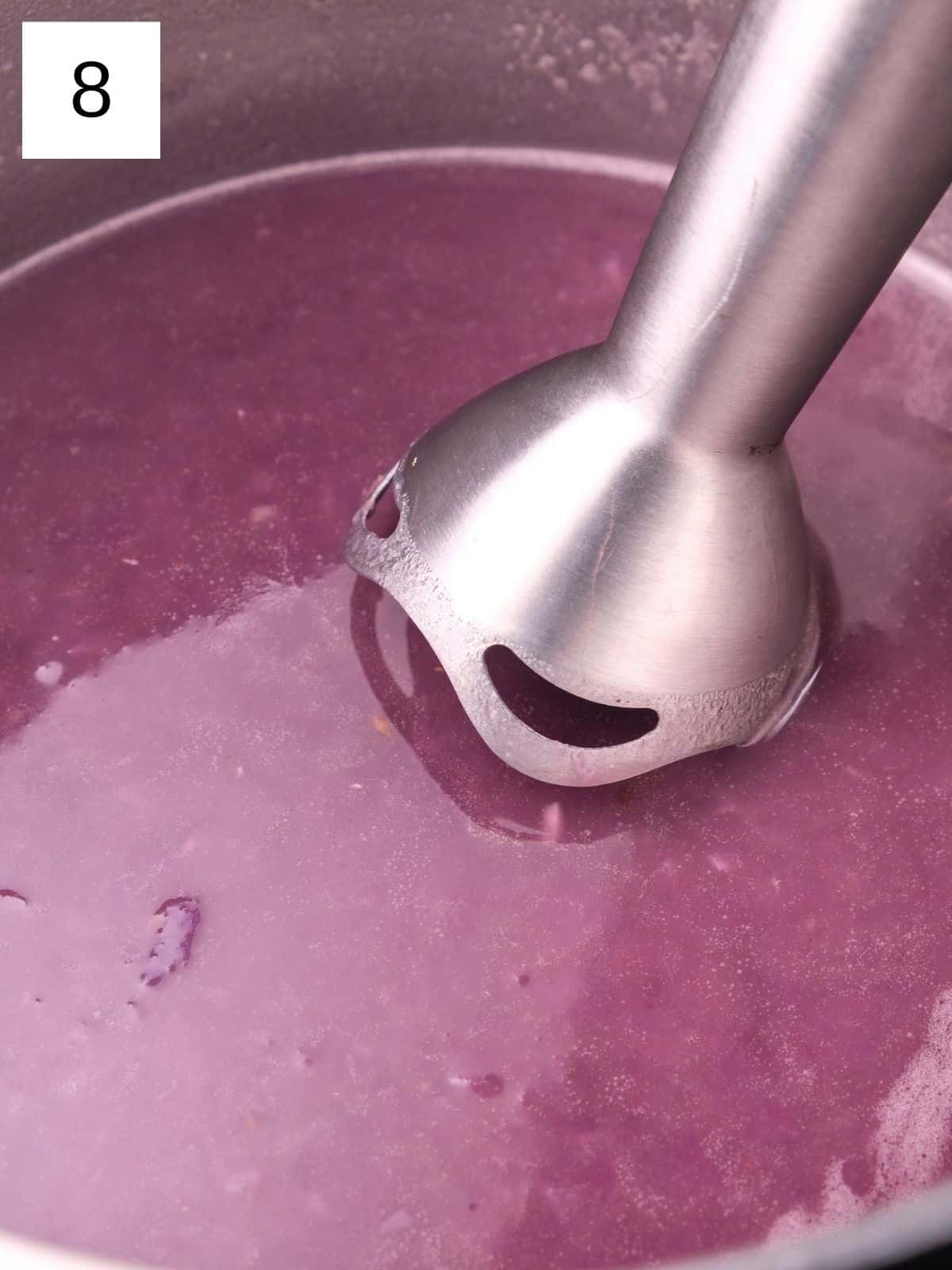 blending the soup using an immersion blender.