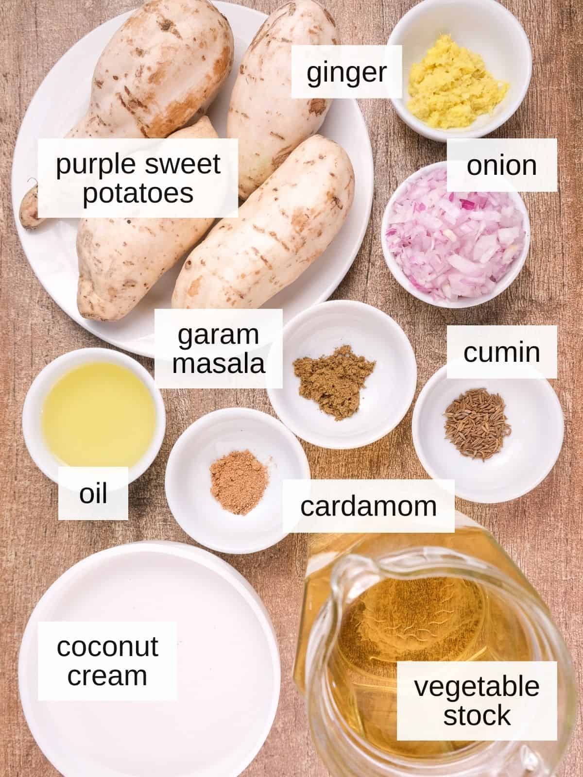 ingredients for purple sweet potato soup, including ginger, onion, garam masala, cumin seeds, cardamom, oil, coconut cream, vegetable stock, and purple sweet potatoes.