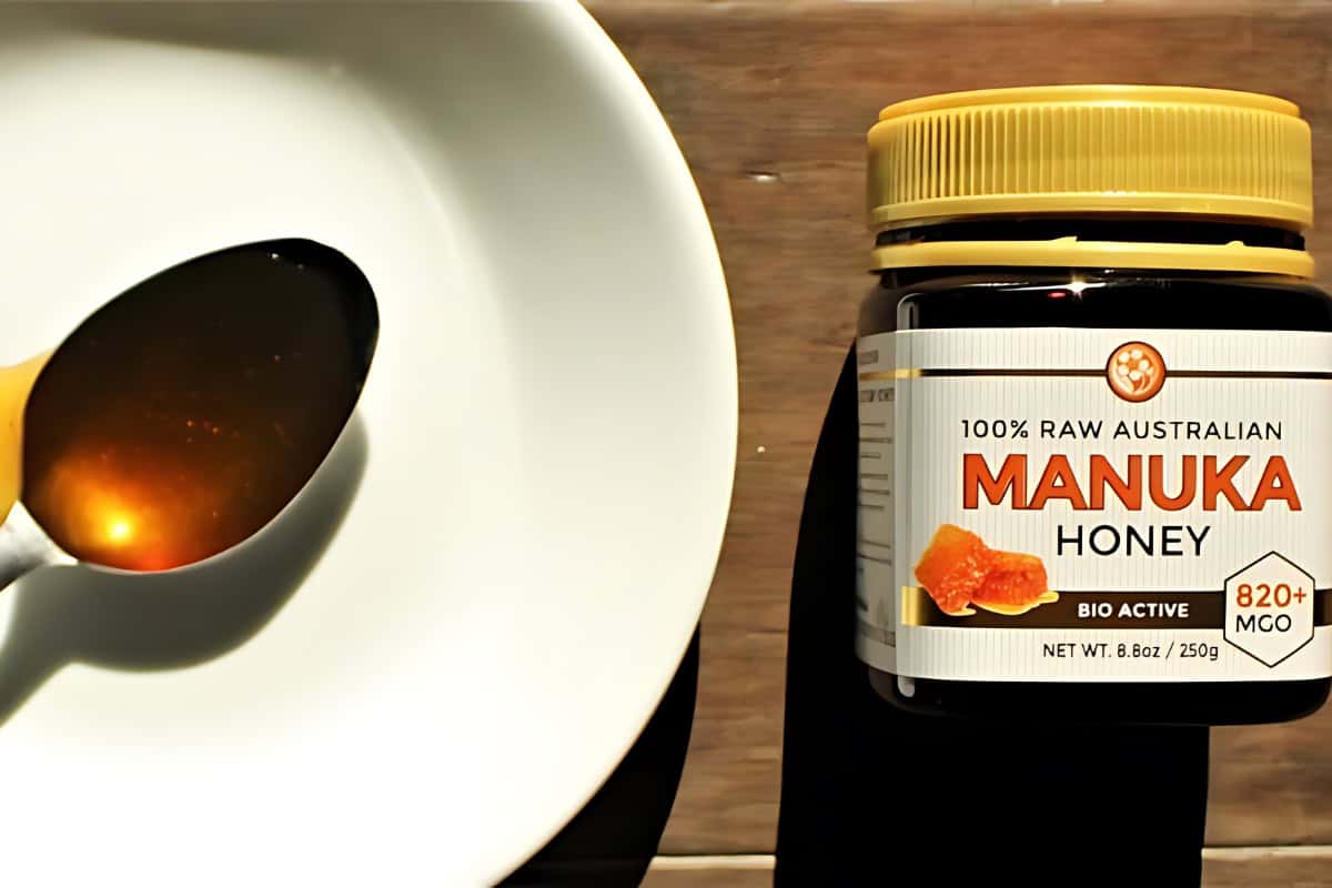A spoon full of Hanuka honey next to a jarred Hanuka honey. 