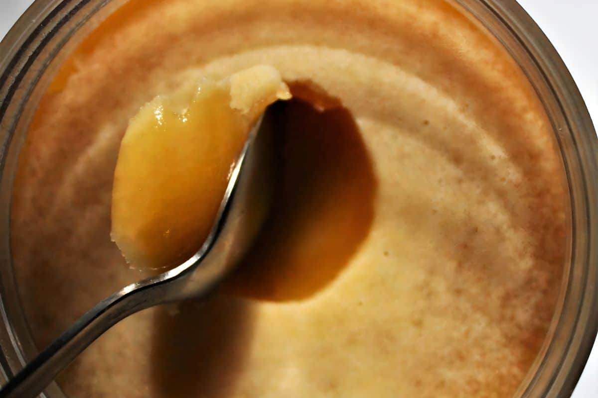 Raw Manuka honey being scooped with a spoon. 