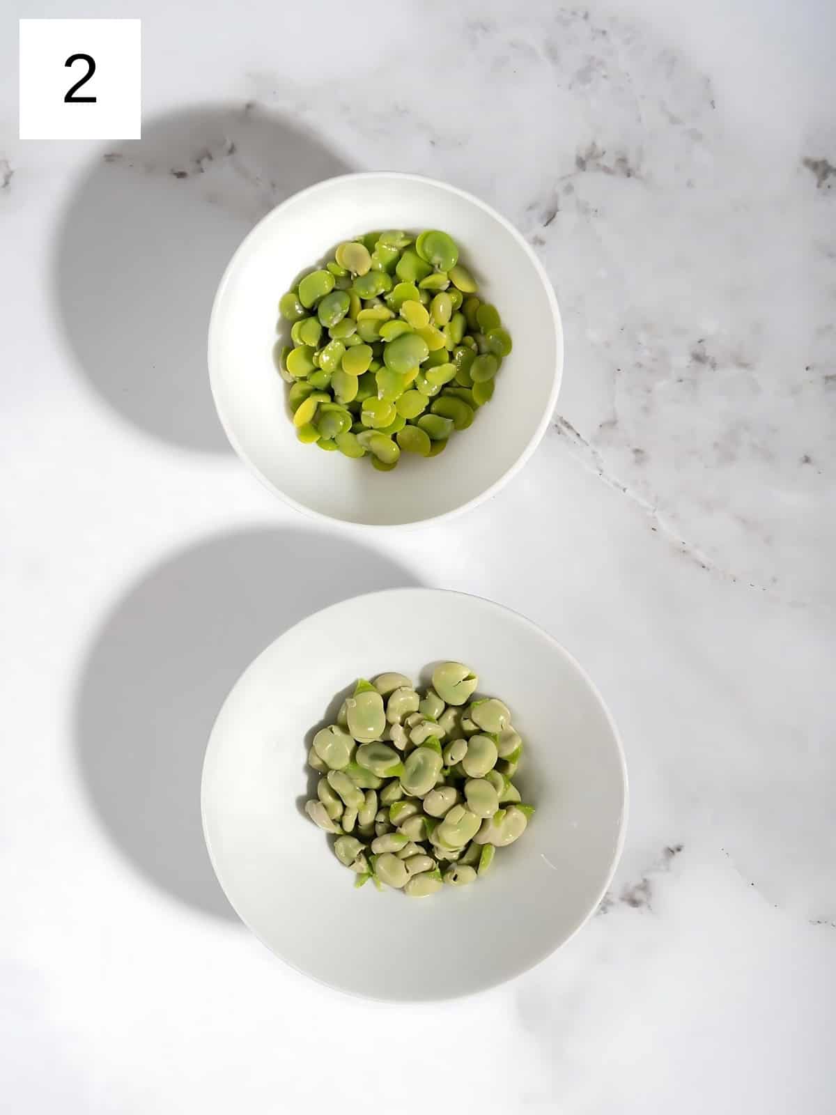 Peeled and de-shelled fava beans separated into bowls.