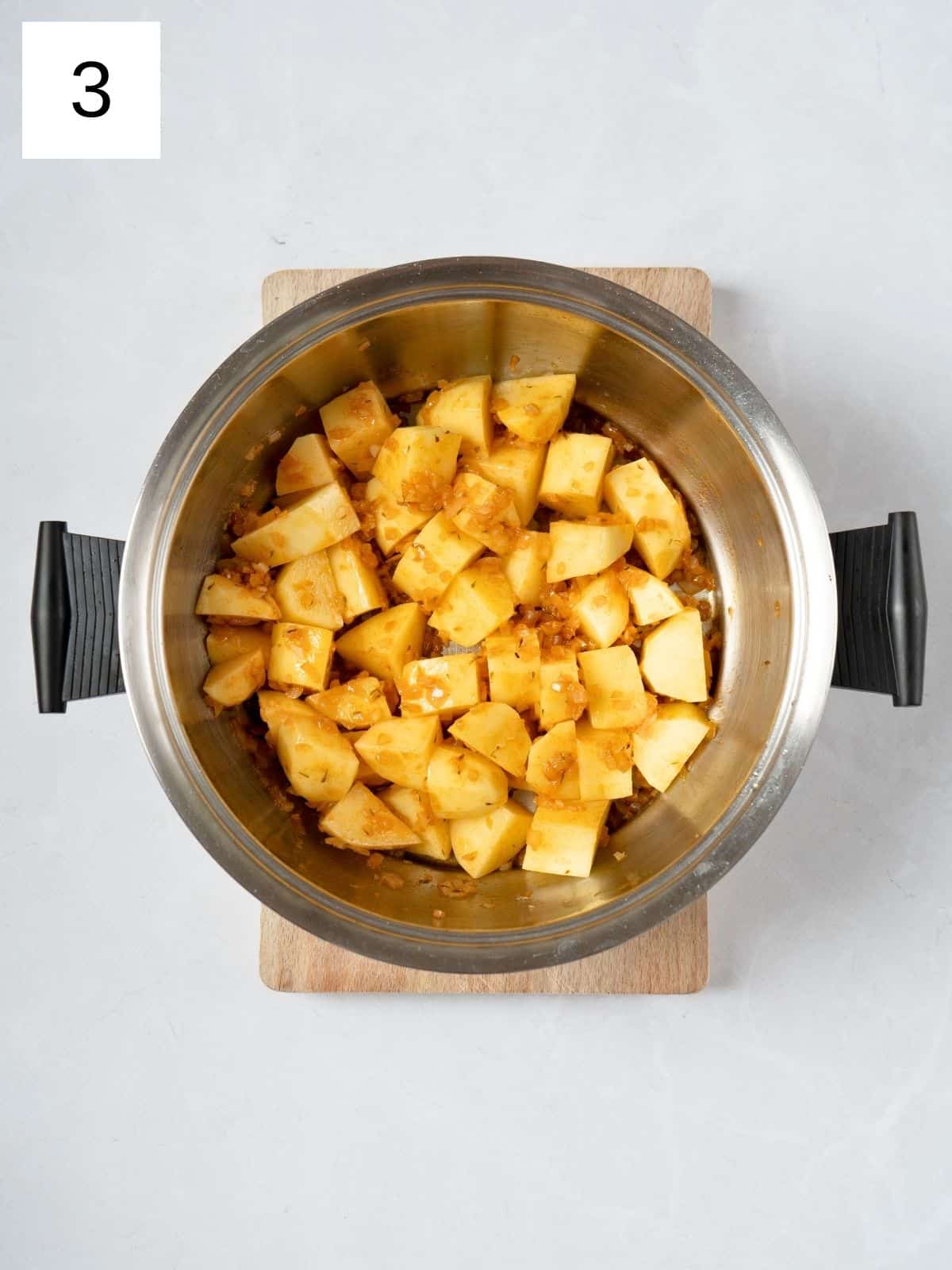 sliced potatoes, coated with oil and spices, in a pot.