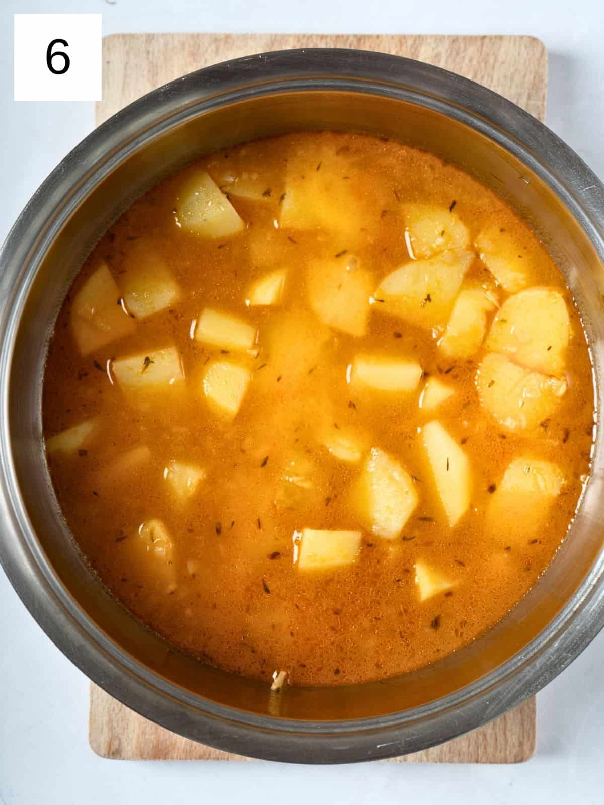 a mixture of vegetable broth and seasoned potatoes in a pot.