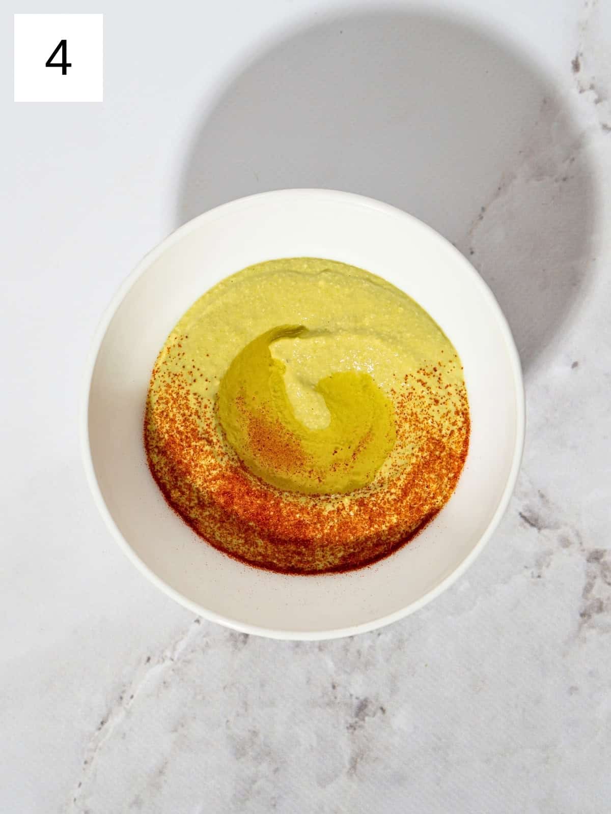 Fava bean hummus in a bowl sprinkled with paprika and a dash of olive oil.