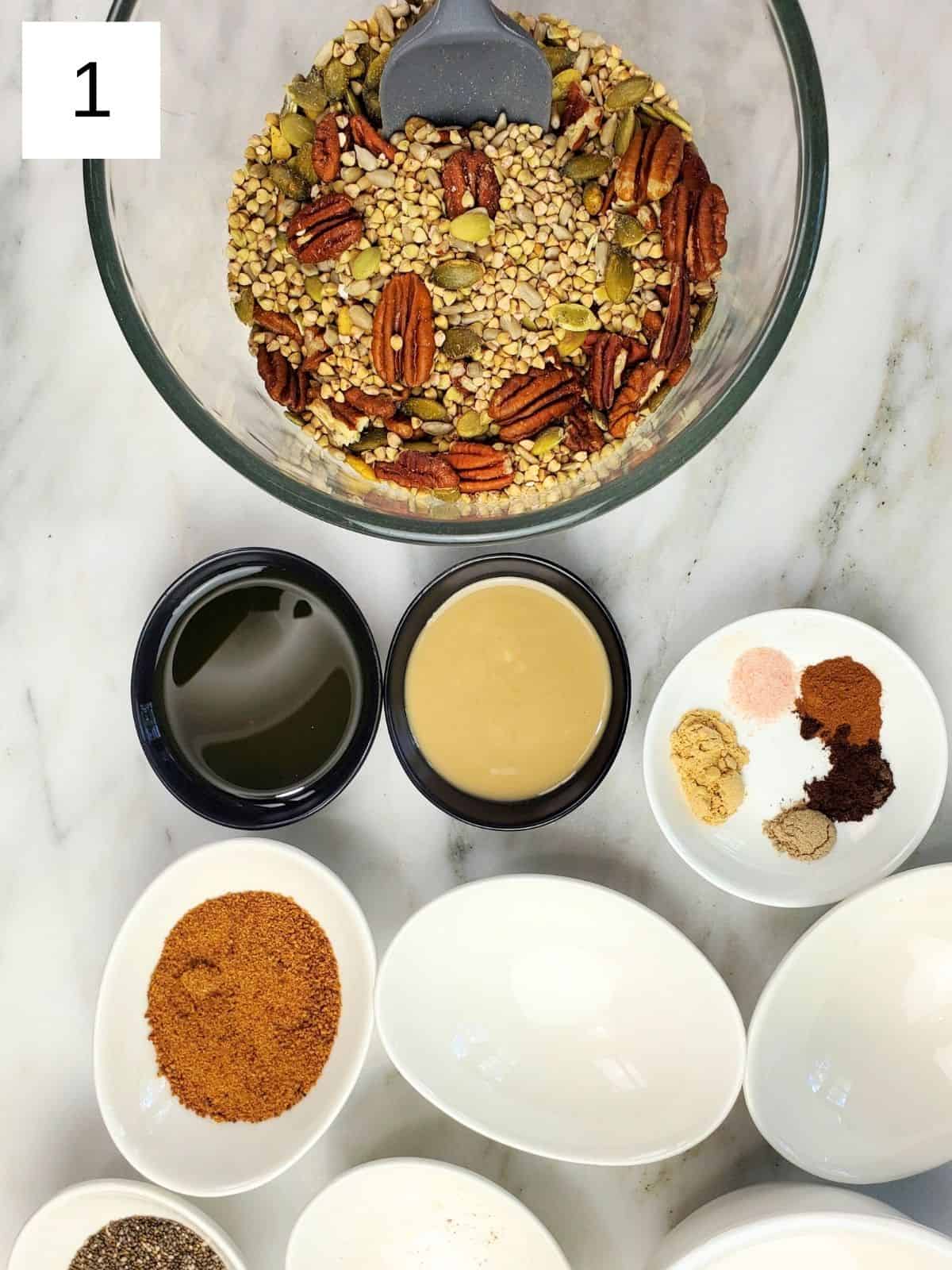 Pecans, puffed buckwheat, pumpkin seeds, and sunflower seeds combined in a bowl.