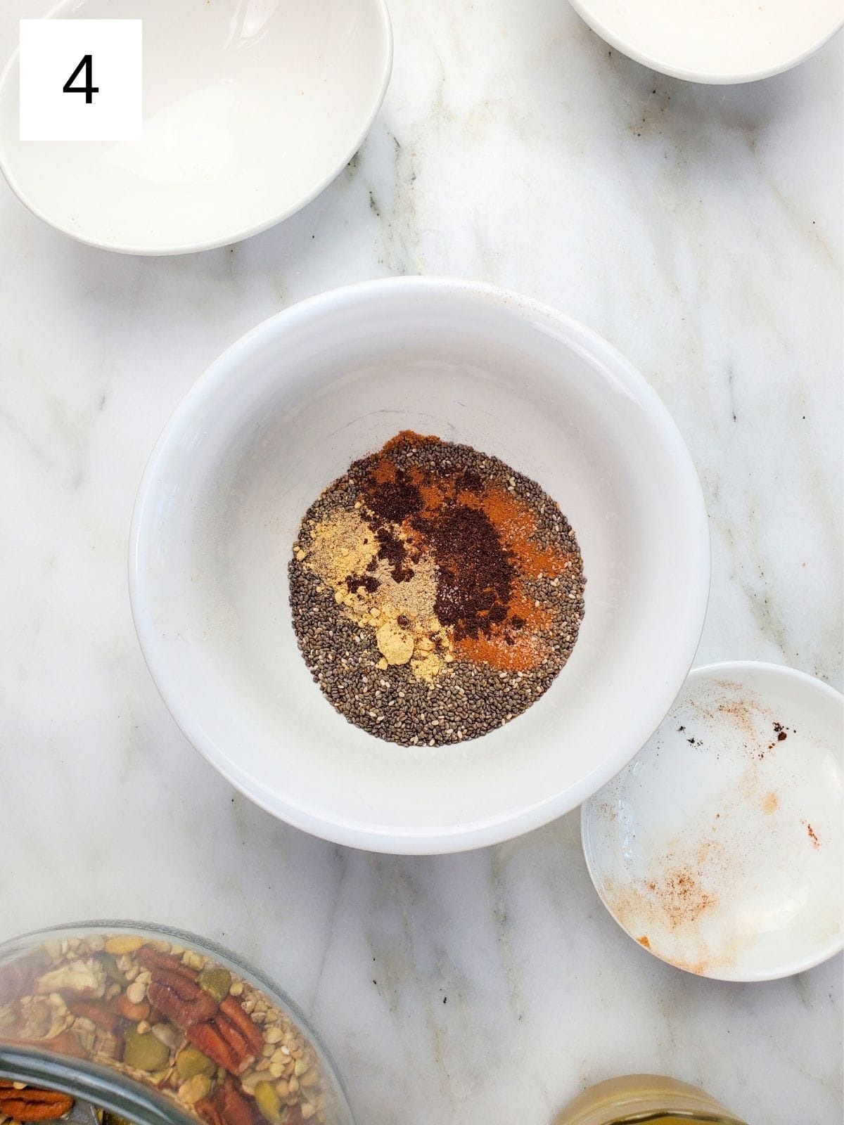 Chia seeds, vanilla powder, cinnamon, cardamom, and ginger powder combined in a single bowl.