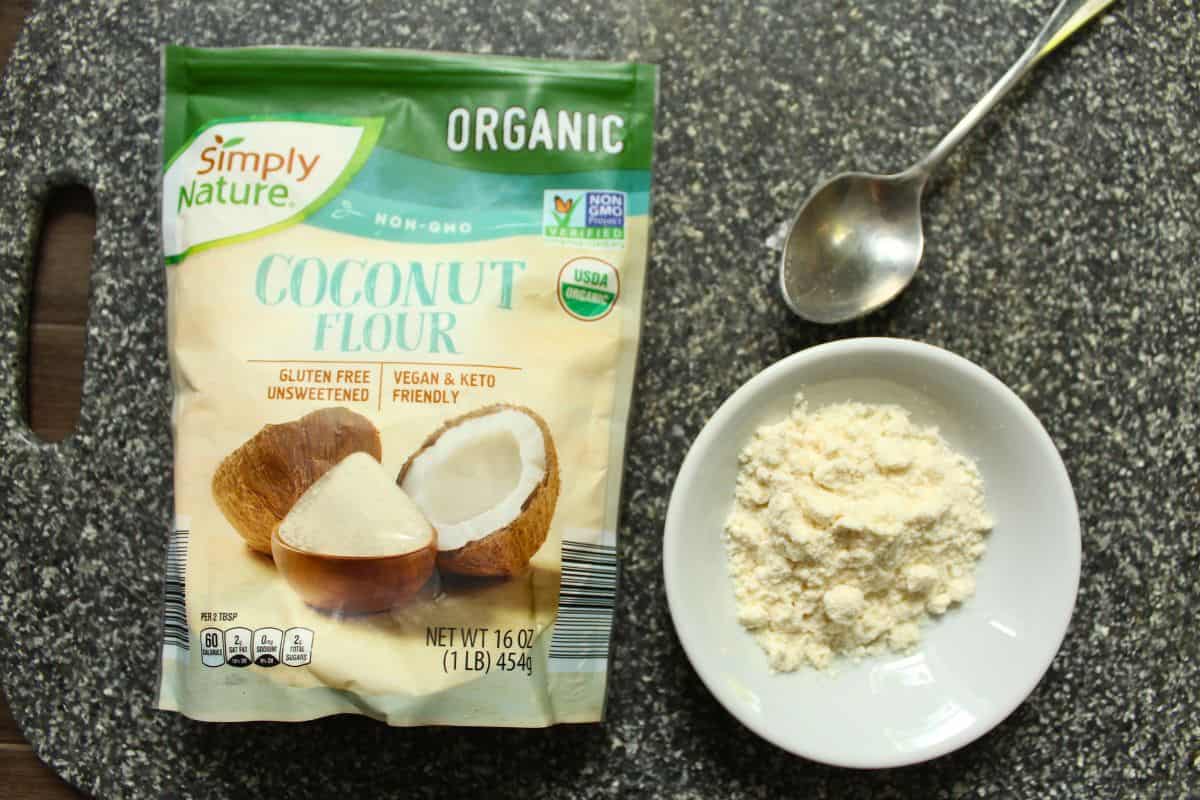 A pack of coconut flour next to a bowl of coconut flour. 