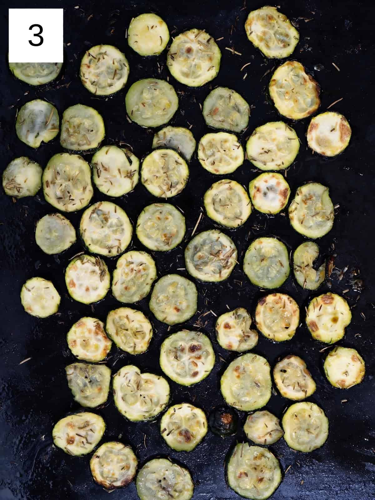 Fresh roasted zucchini disks in a baking tray.