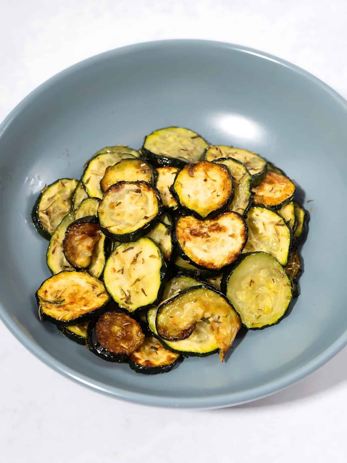 Herb roasted zucchini disks in a bowl.