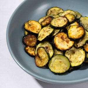 Herb roasted zucchini disks in a bowl.