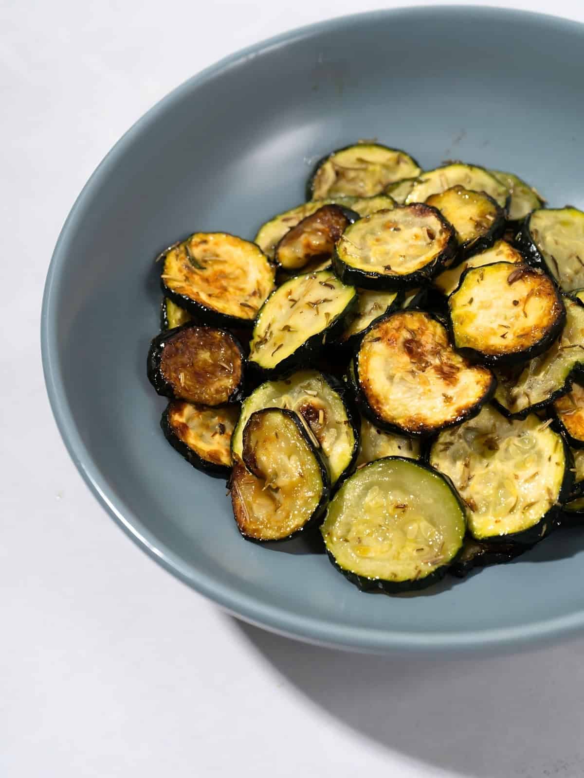 Herb roasted zucchini disks in a bowl.