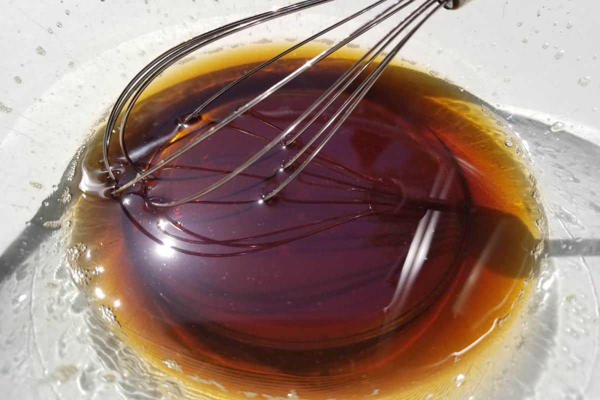 A bowl of brown sugar syrup and a whisk.