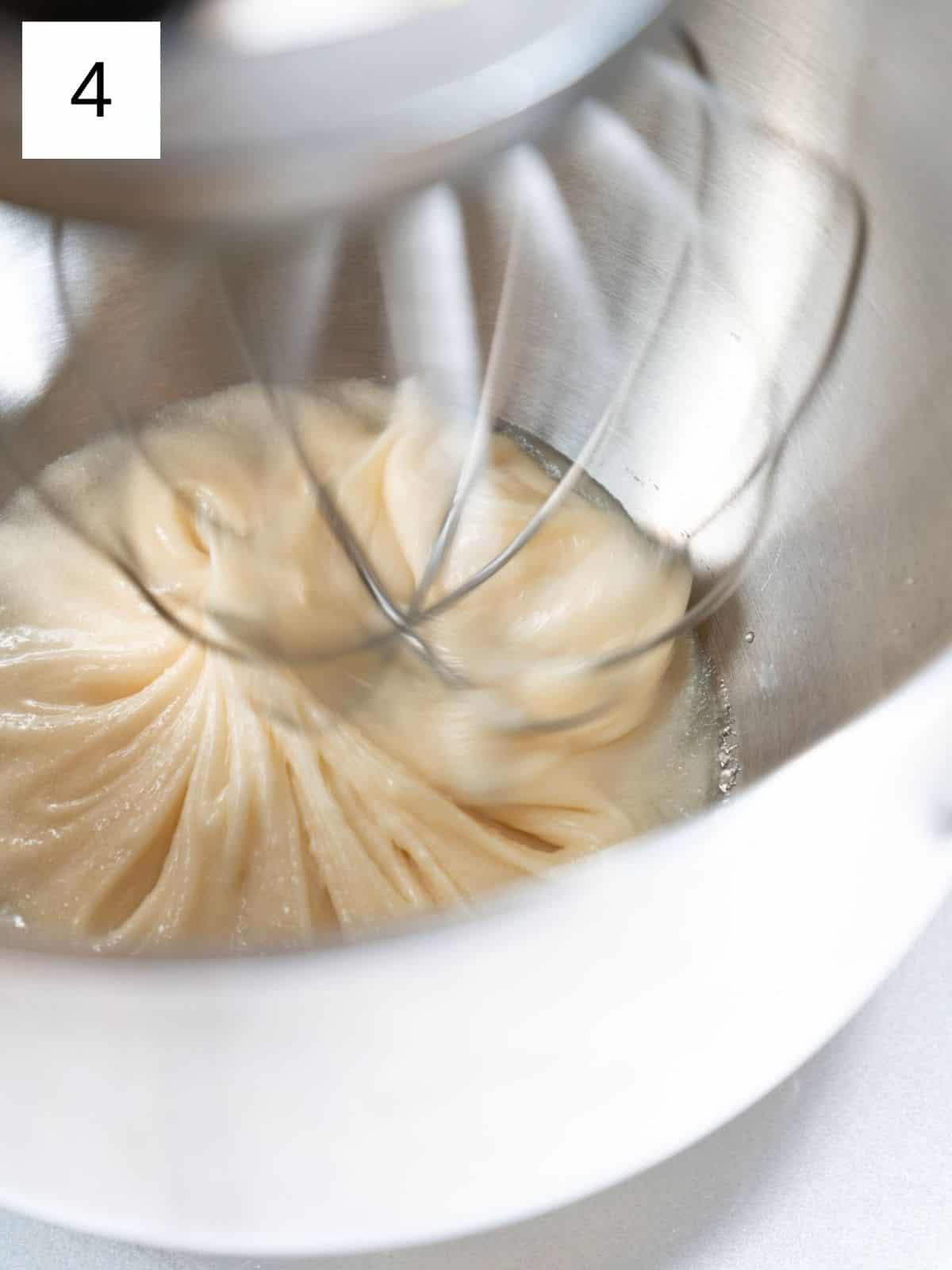 Honey being whipped in a stand mixer until light and creamy.