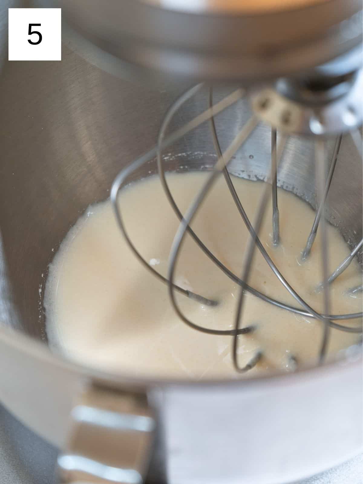 A stand mixer whipping honey into a smooth, fluffy texture.