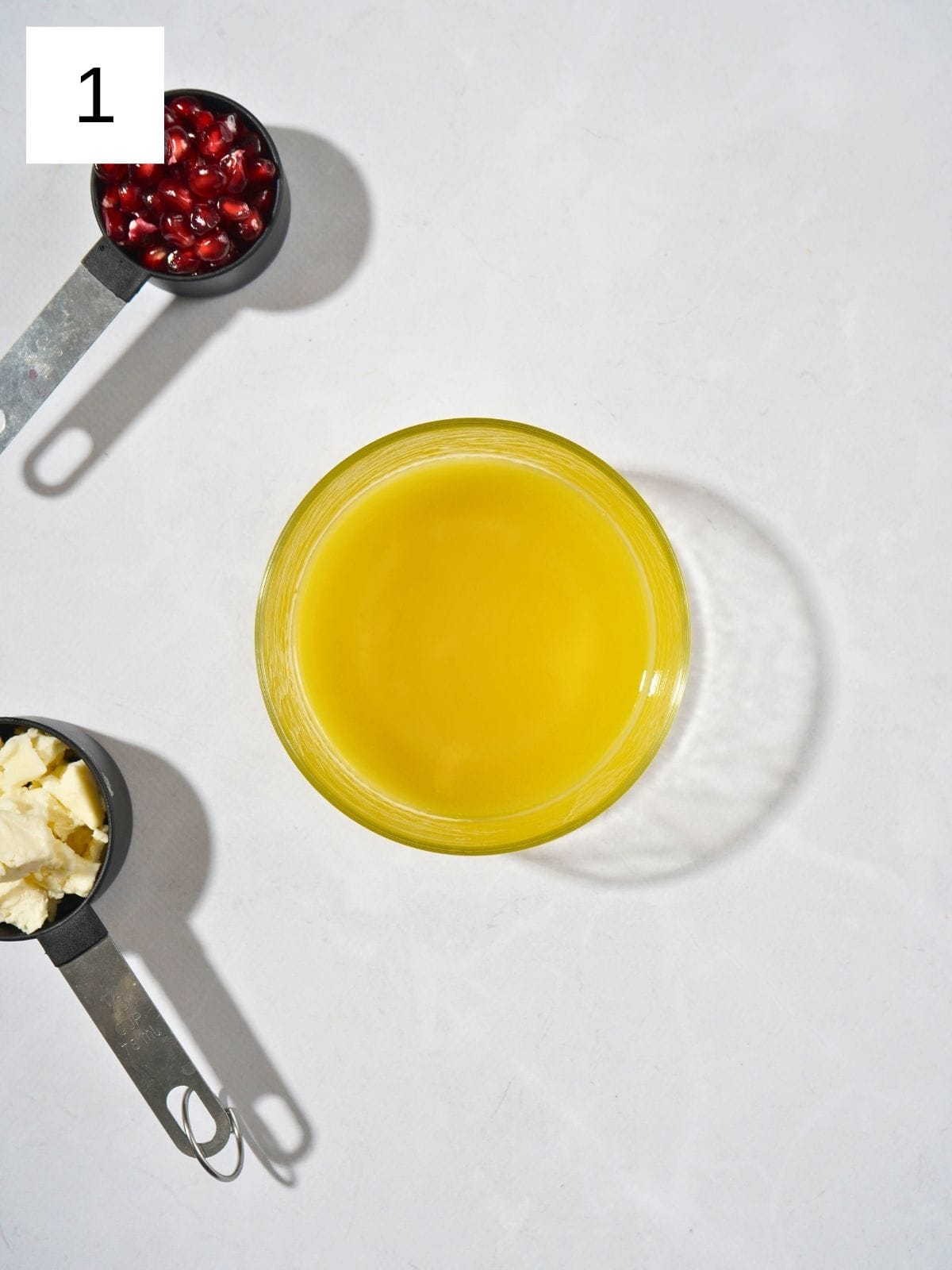 A small saucer filled with a golden salad dressing made with olive oil, vinegar, honey, and a touch of salt, glistening and ready to drizzle.