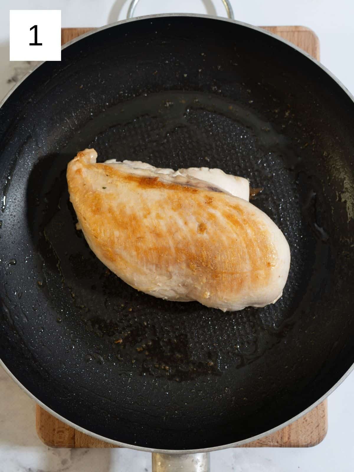 Golden-browned chicken breast sizzling in a skillet, perfectly seared for a delicious and flavorful meal.