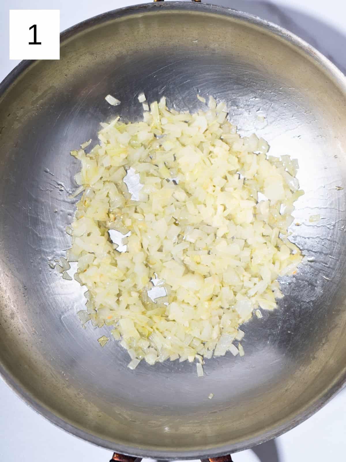 Freshly chopped onion and minced garlic cooking in a pot, releasing aromatic scents.