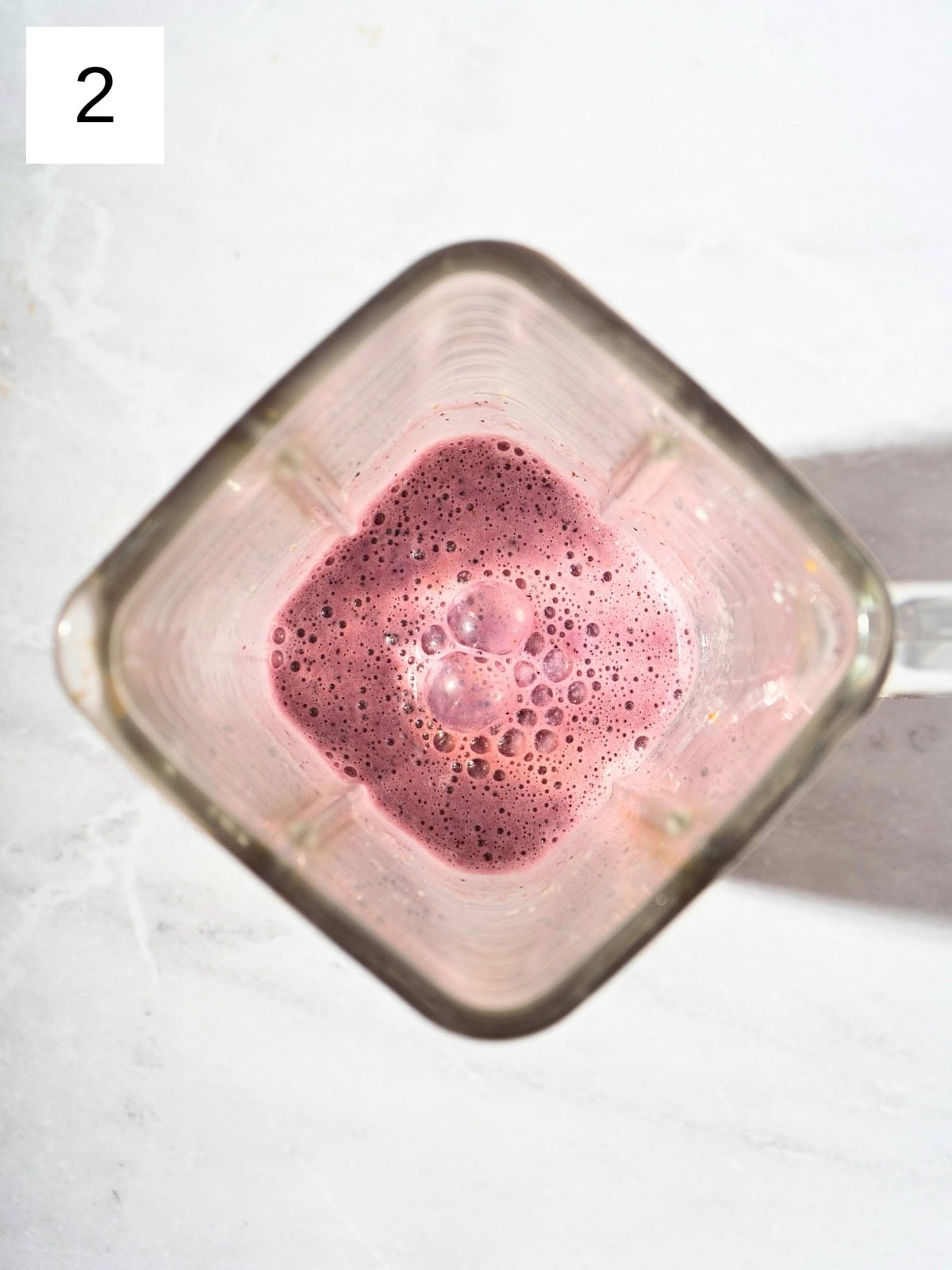 Blended mixture of blueberry cucumber smoothie in a blender.
