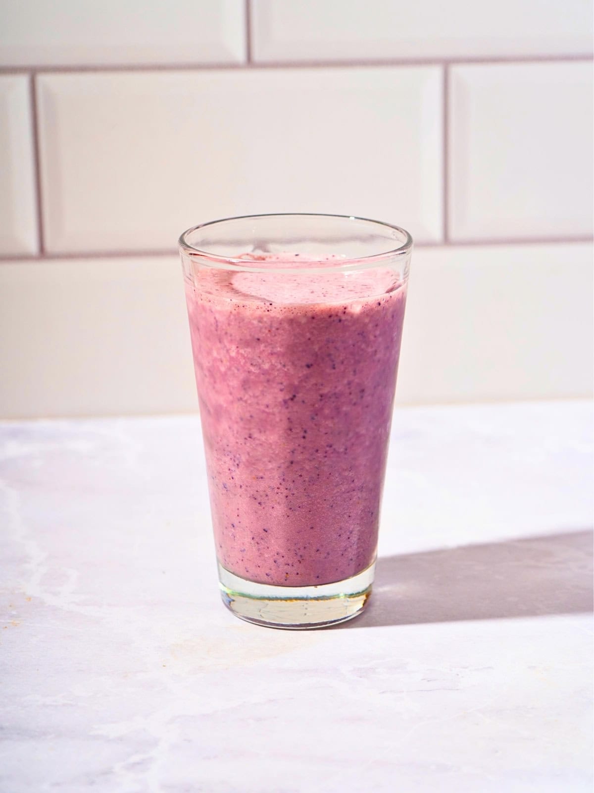 Refreshing blueberry cucumber smoothie served in a glass.