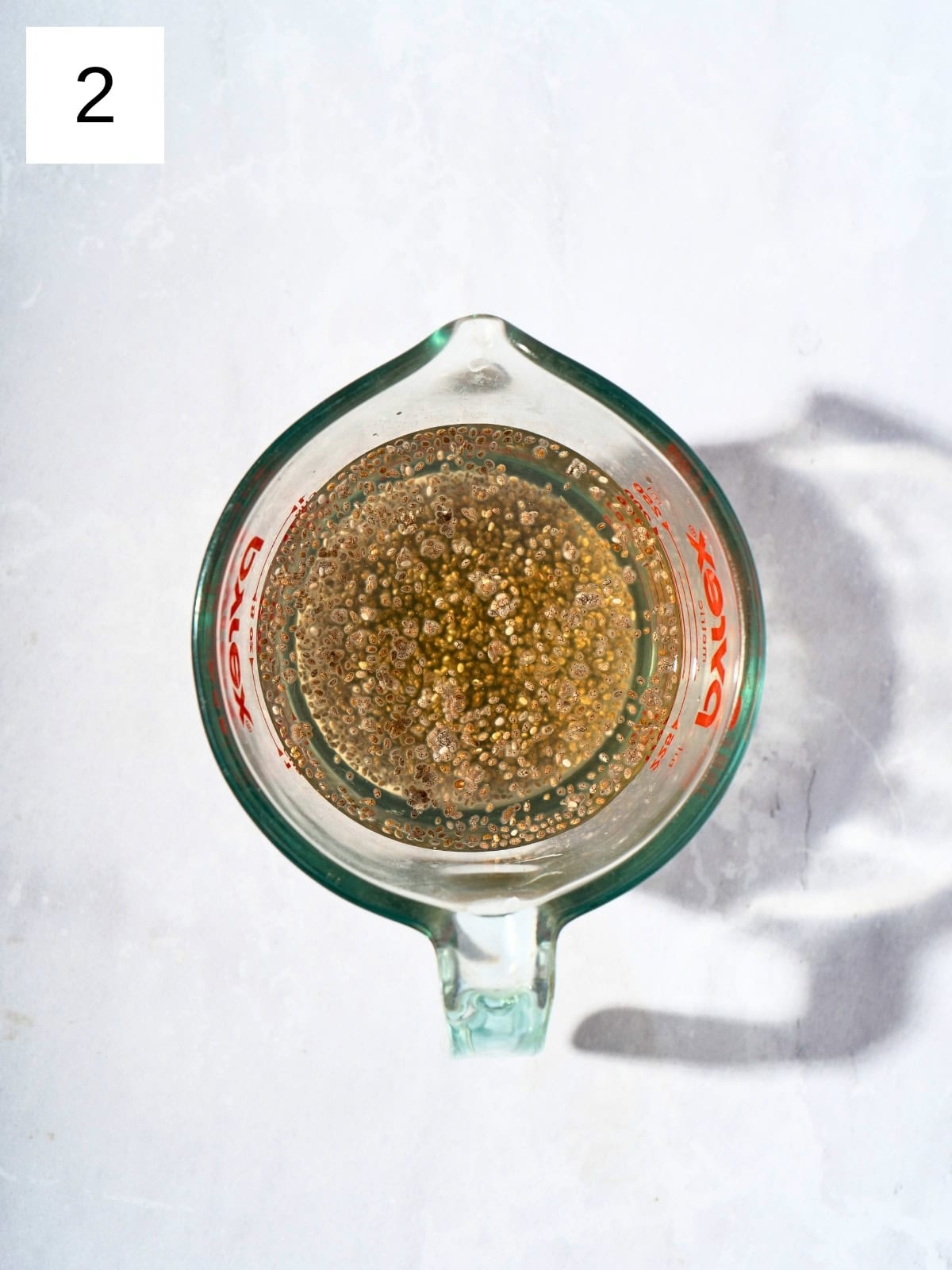 A mixture of chia seeds and apple juice in a mixing cup.