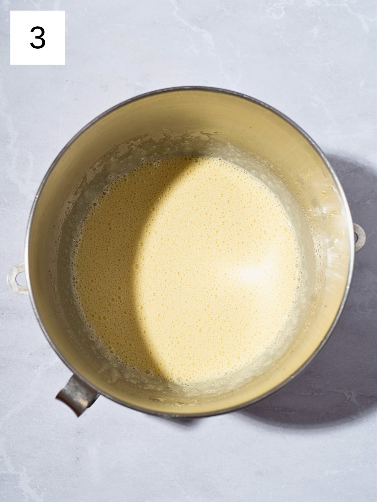 A mixture of olive oil, granulated sugar, eggs, and milk in a large mixing bowl.