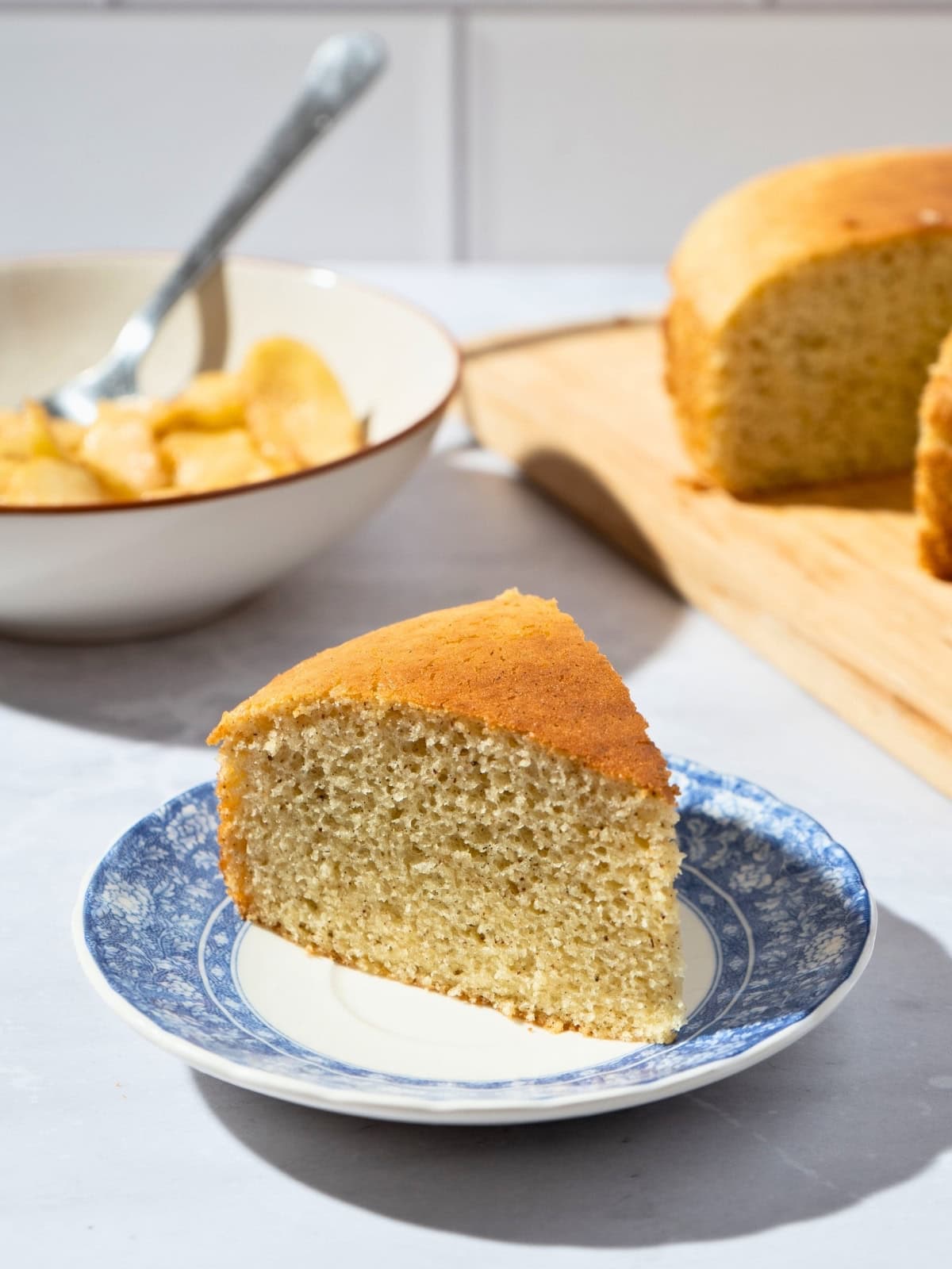 A single slice of vanilla cake with a golden crust, plated and ready to enjoy.