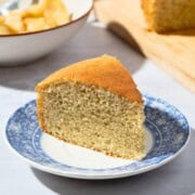 A slice of moist dairy-free vanilla cake served on a white plate, showcasing its tender crumb and light texture.