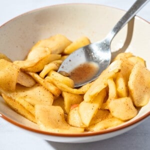 Warm stewed apples served in a bowl, with soft apple slices and a sprinkle of cinnamon.