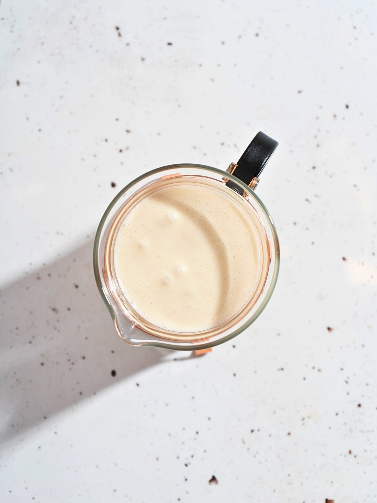 Smooth and creamy ginger garlic sauce served in a transparent glass jar.