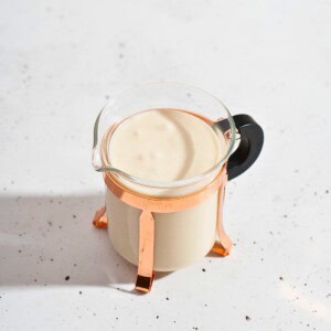 Creamy ginger garlic sauce in a clear glass container showcasing its smooth texture and rich color.